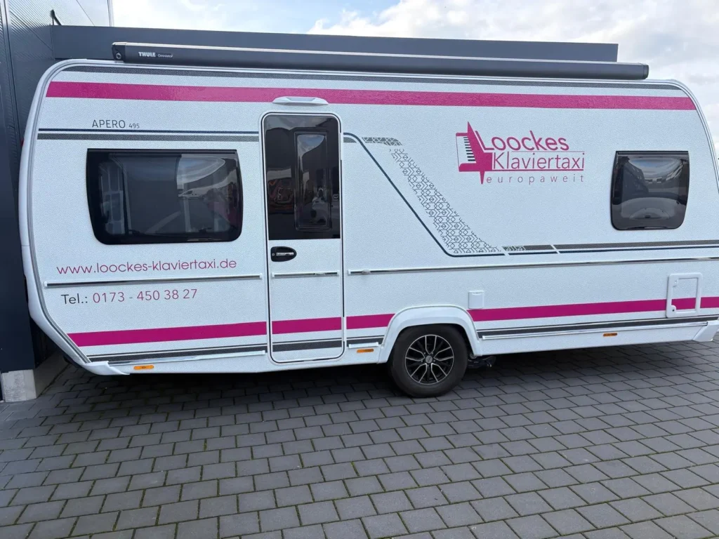 Wohnwagen von Loocke's Klaviertaxi mit Firmenbeschriftung, bereit zur Vermietung